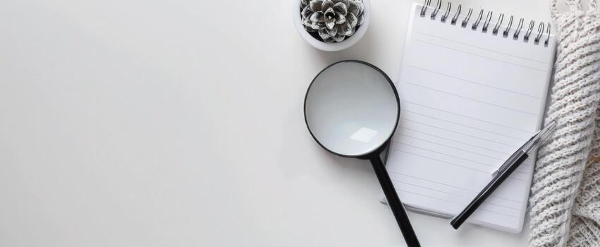 magnifying-glass-on-notepad-with-pen-and-succulent-plant-on-white-surface-free-photo